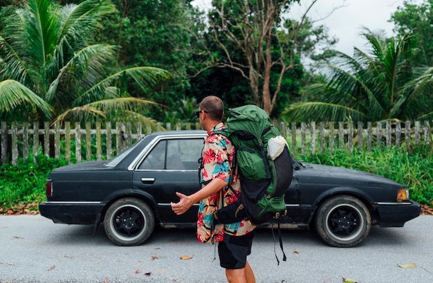 Man with flower shirt hitchhiking