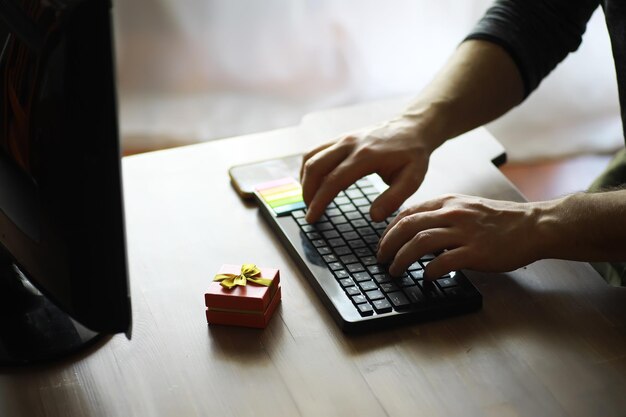 a man with a gift in his hand sits in front of the monitor screen order a gift for home and office