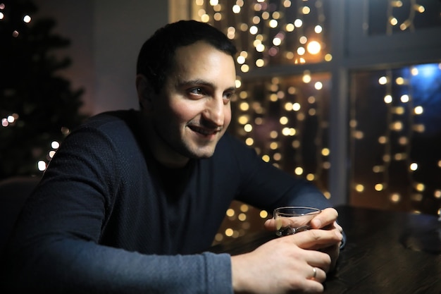 Man with glass of whisky in the pub on night