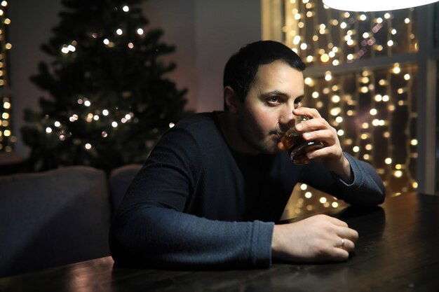 Man with glass of whisky in the pub on night