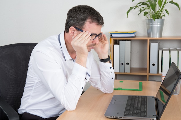 Man with glasses working on his notebook