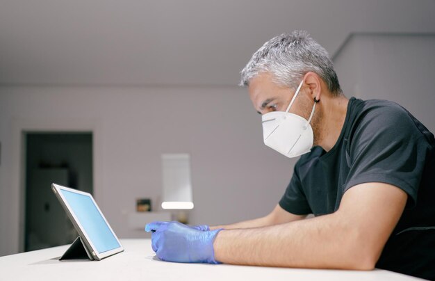 Photo man with gloves, mask and a table covid19