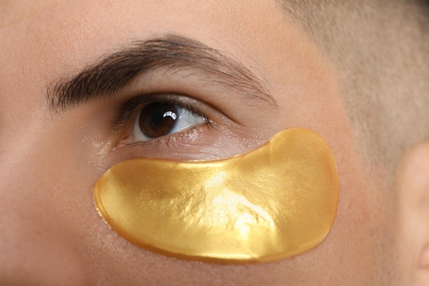 Man with golden under eye patch closeup