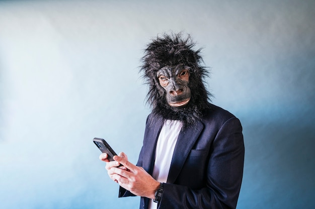 Foto uomo con maschera di gorilla utilizza lo smartphone