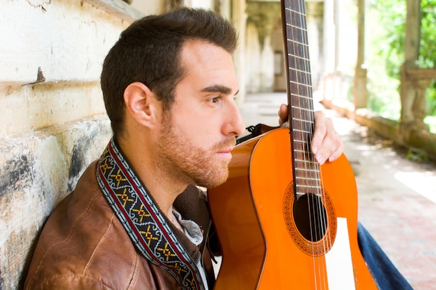 Foto uomo con la chitarra in un edificio in stile urbano in rovina