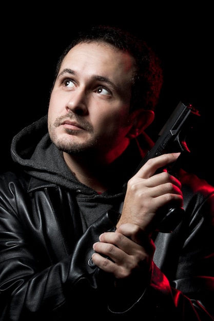 Photo man with a gun and dressed in black leather