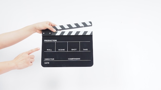 A man with hands is holding black Clapperboard or movie slate. it use in video production ,film, cinema industry.It is white background.