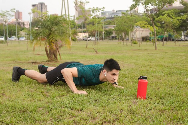 Man with headphones doing push-ups in the square.