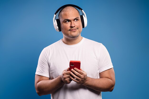 Photo man with headphones holding a smartphone