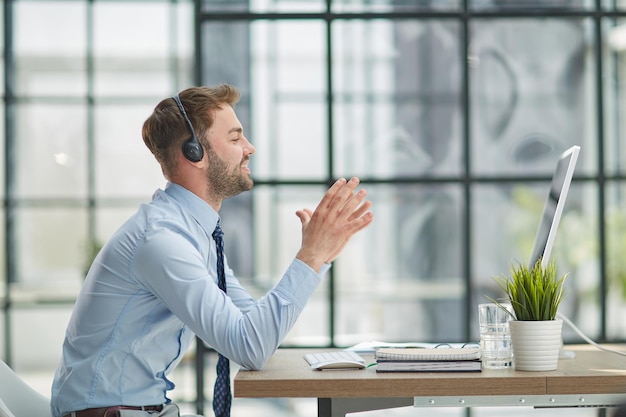 Man with headphones and laptop working in office