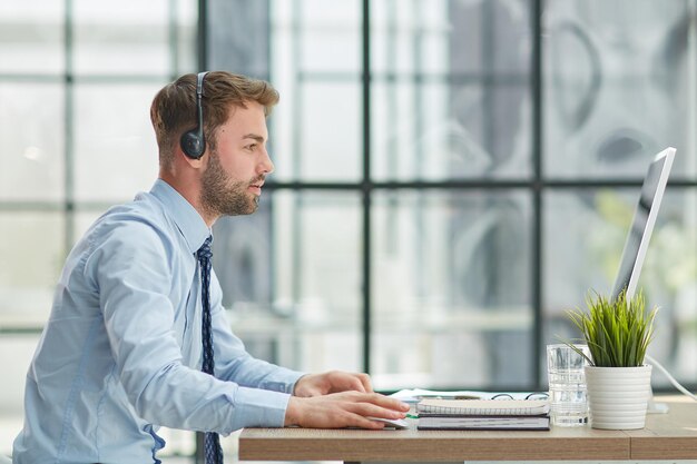 Man with headphones and laptop working in office