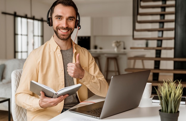 Photo man with headset having video call on laptop