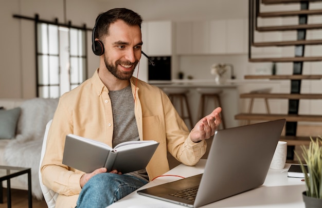 Photo man with headset having video call on laptop