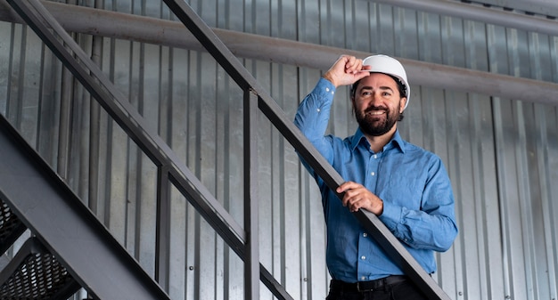 Foto uomo con il casco che lavora in magazzino