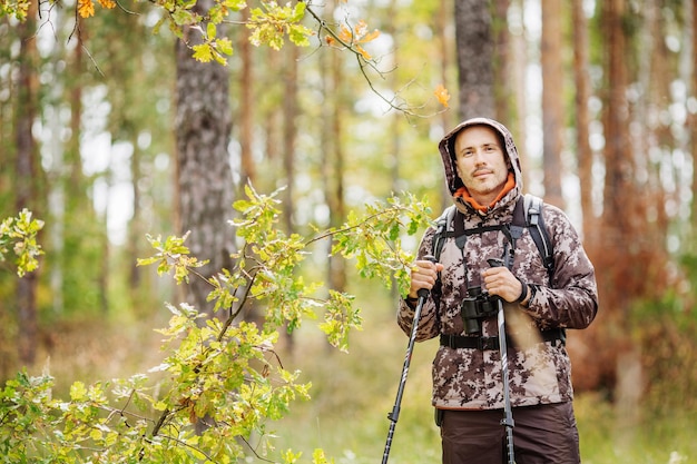 Человек с походным снаряжением гуляет по лесу