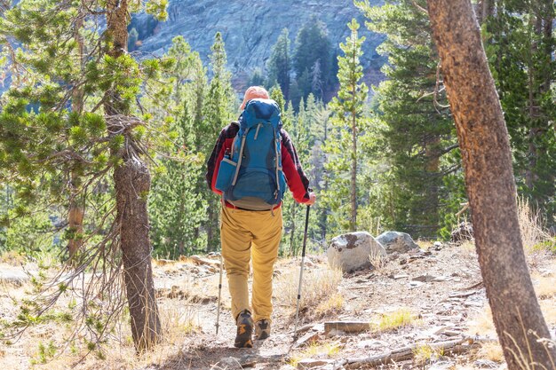 シエラネバダ山脈、カリフォルニア、米国を歩くハイキング用品を持つ男