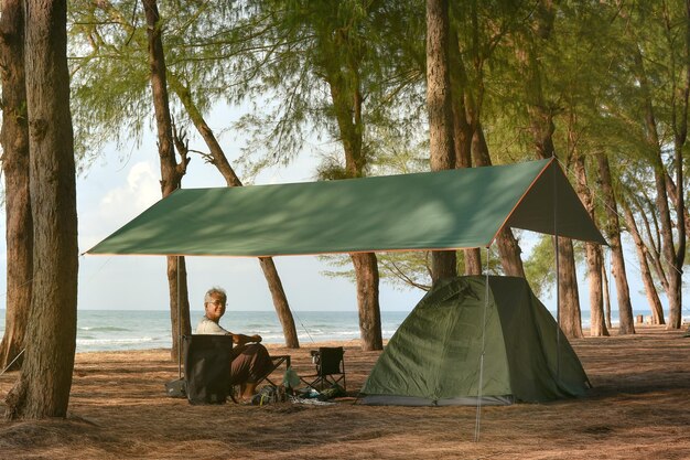 A man with his camping stuff at the seaside