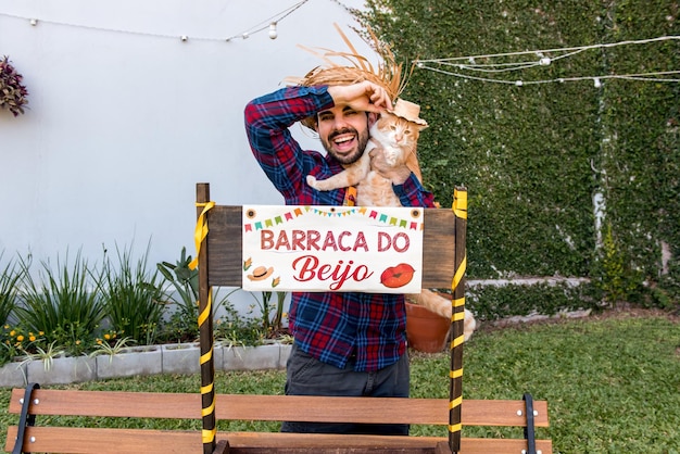 Photo man with his cat in brazilian festa junina translation kissing booth