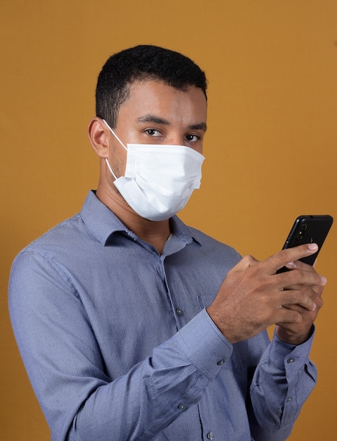 Man with his cellphone wearinga a mask