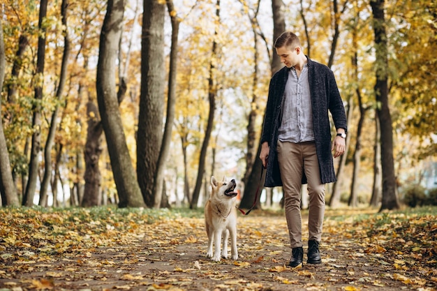 Man with his dog walking in autumn park