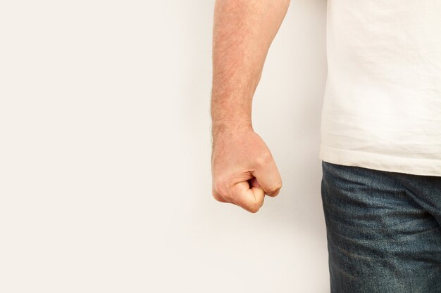 Man with his fist clenched on a white