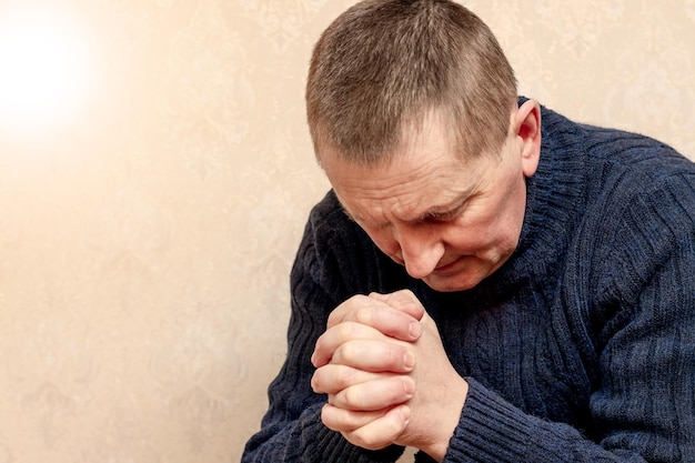 A man with his head bowed during prayer a Christian prays