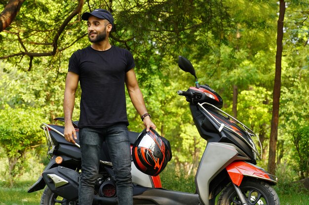 A man with his new scooter and helmet giving thums up full size image