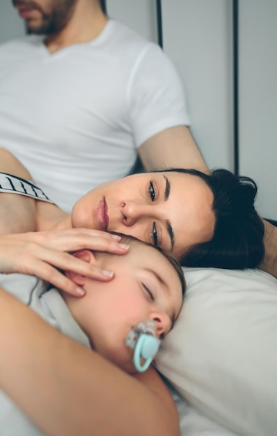 Uomo con sua moglie che veglia su suo figlio mentre dorme