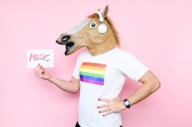 Man with horse mask holding a poster that plays music with pink