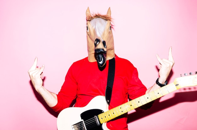 Man with horse mask playing electric guitar