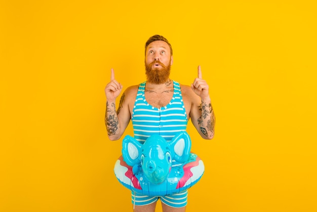 Man with inflatable donut with elephant is ready to swim