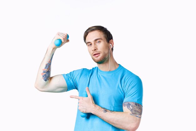 Man with inflated arm muscles shows finger to the side and dumbbells bodybuilder fitness