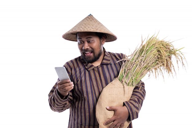 Man with Javanese traditional lurik shirt holding rice grains