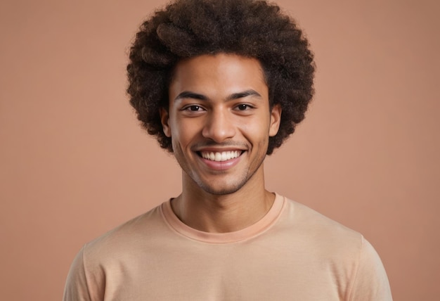 A man with a joyful expression and curly hair wears a beige shirt his smile exudes warmth and