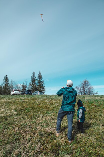 Uomo con bambini che giocano all'aperto con l'aquilone