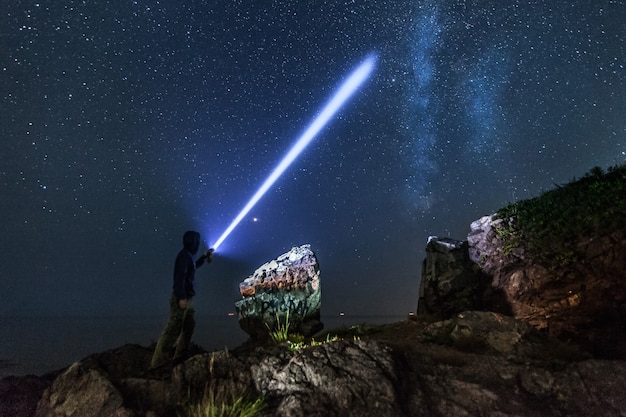 Uomo con lanterna sotto il cielo stellato e la via lattea