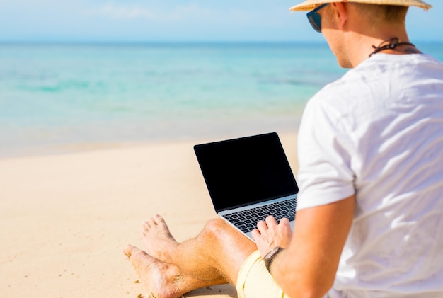 Man with laptop on the beach
