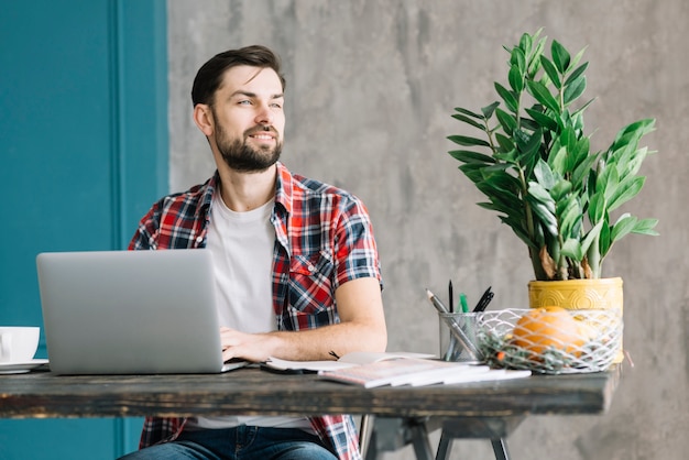 Man with laptop looking away