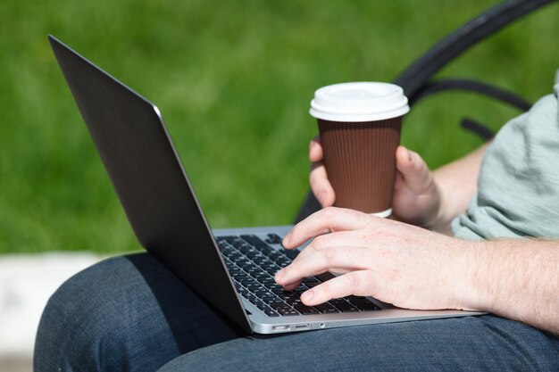 Man with laptop in park on a sunny day