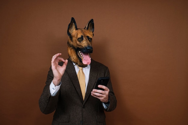 A man with a latex dog head mask and a smartphone