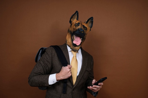 A man with a latex dog head mask and a smartphone