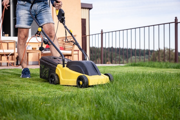 Man with lawn mower, green grass