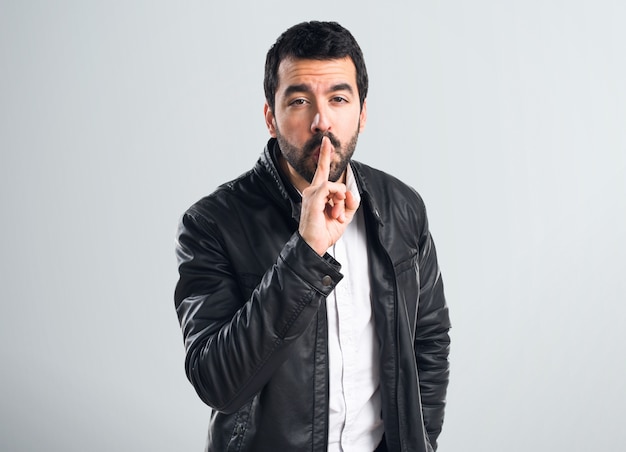 Man with leather jacket making silence gesture