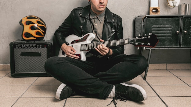 man with leather jacket playing guitar