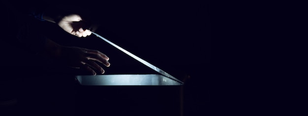 Man with light box on the dark surface