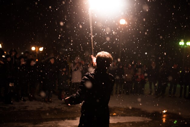 A man with a lighted torch over his head a fire show