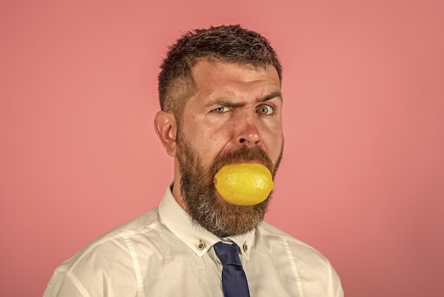 Man with long beard eat lemon