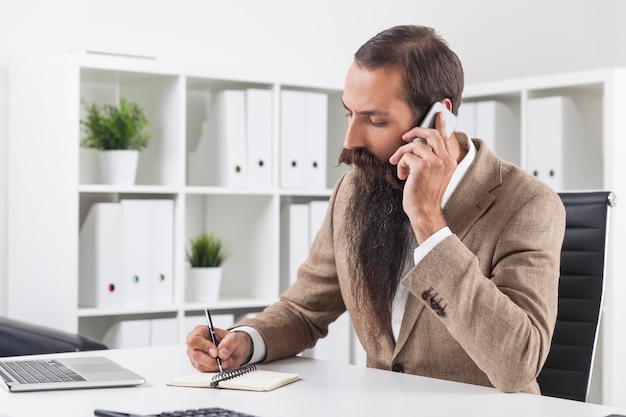 Man with long beard taking notes