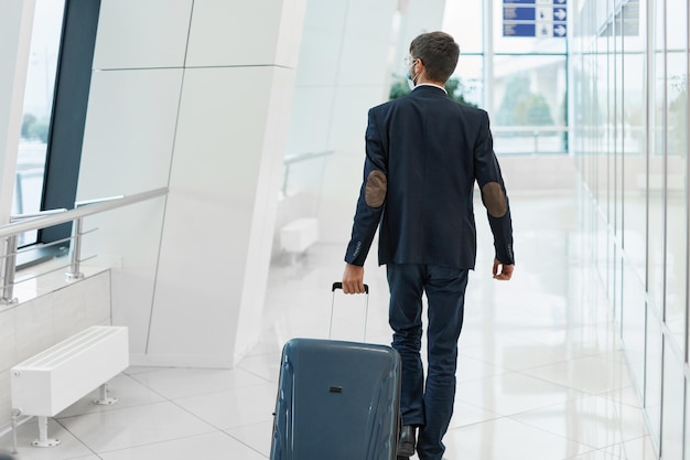 Мужчина с багажом идет в аэропорт
