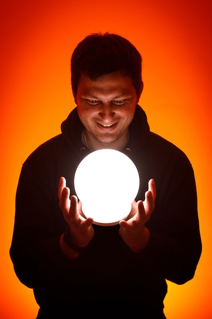 Man with a luminous ball in his hands.